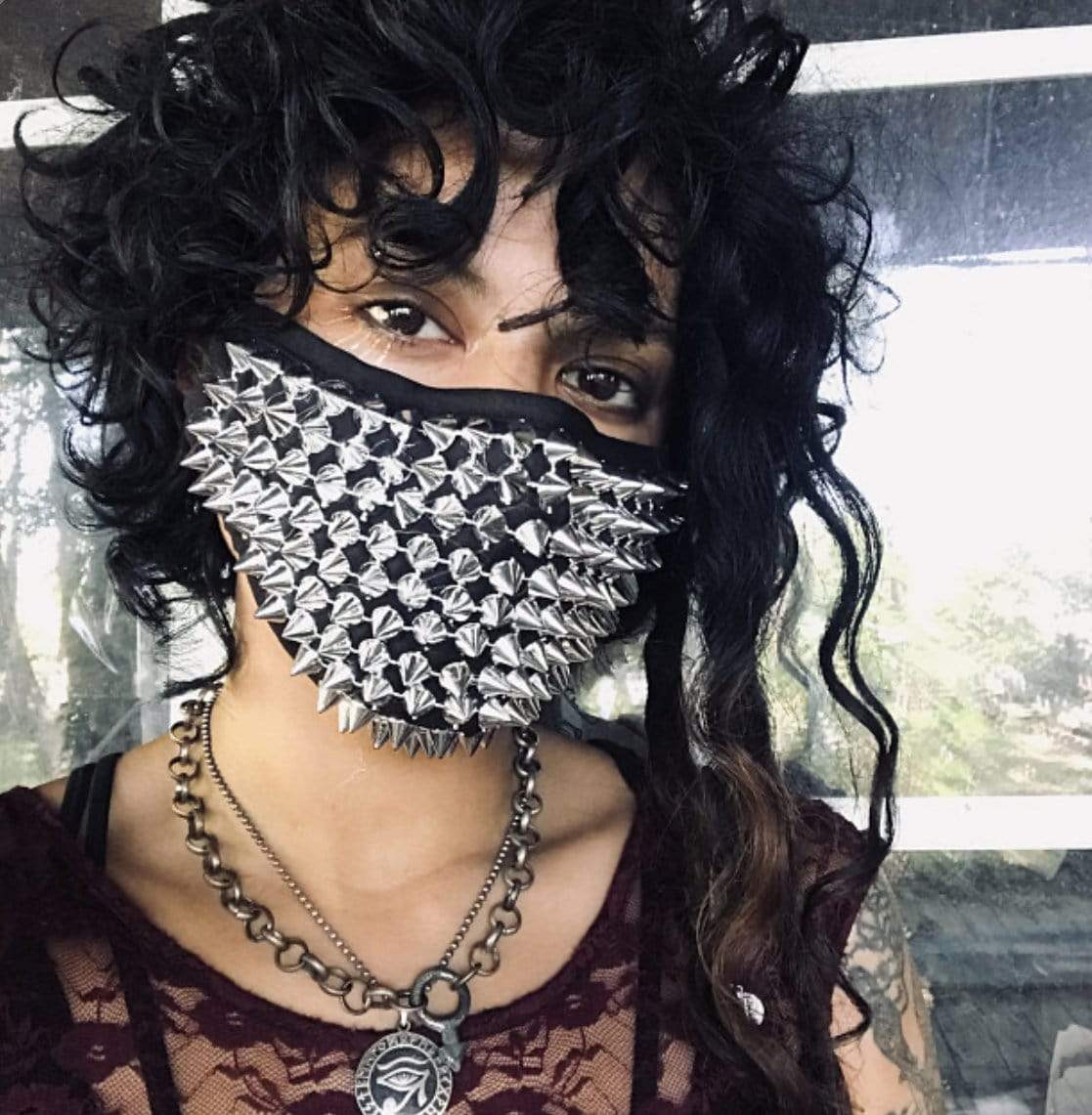 Model in the silver chrome spiked face mask for a futuristic rave look