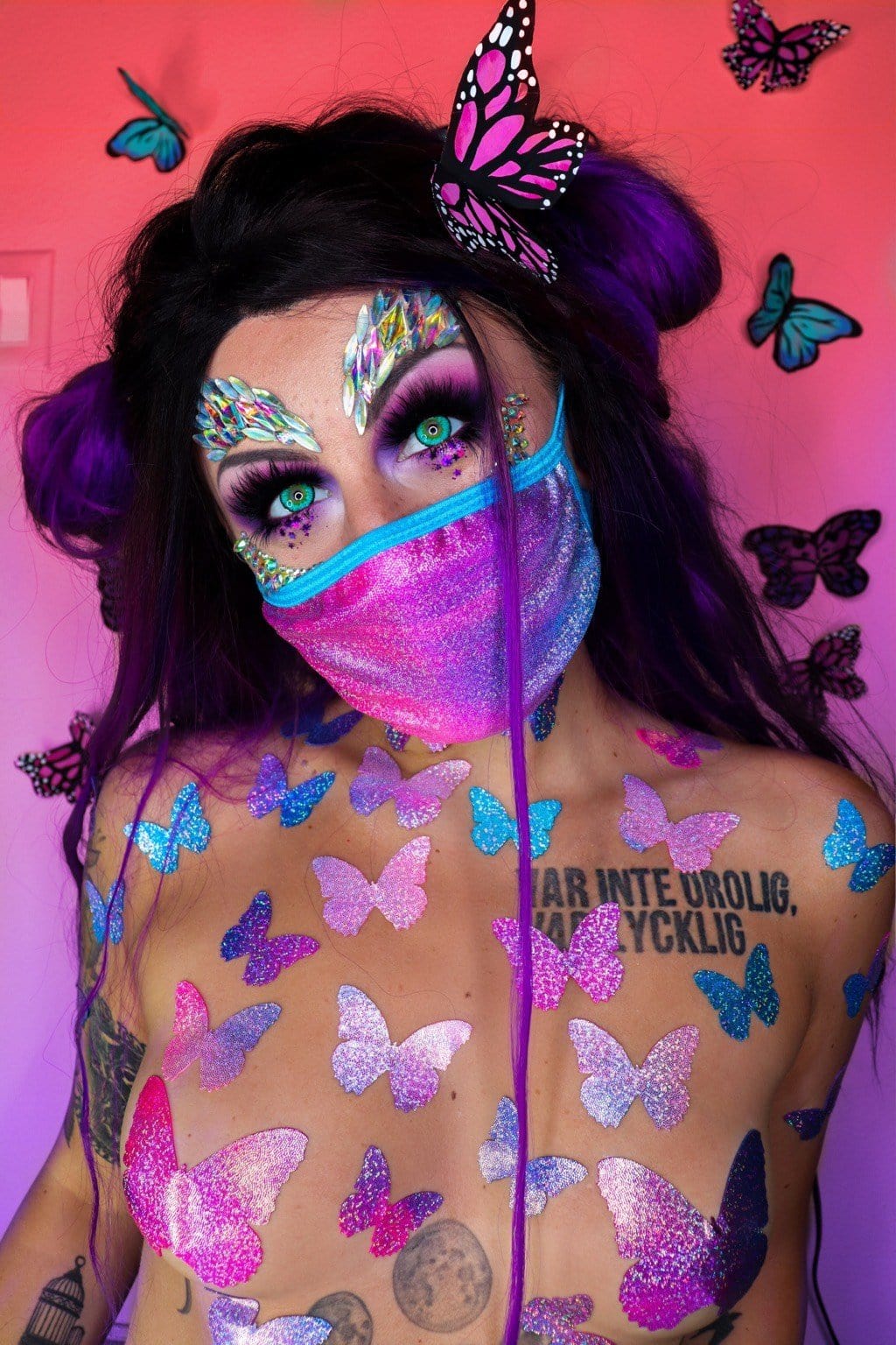 Model wearing pink and blue holographic face mask with matching pasties for a finished look