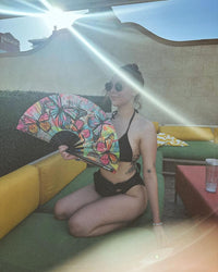 Standalone product shot of the multicolor butterfly blacklight folding fan