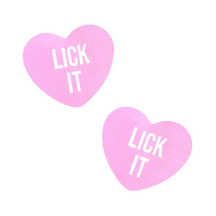 Pair of soft pink candy heart shaped nipple covers with bold printed lettering