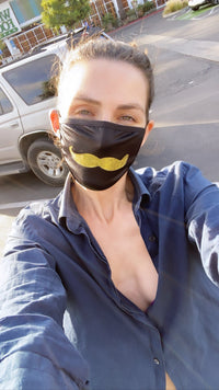 Front view of black face mask with a gold glitter mustache with the full design visible