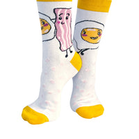 Yellow cotton socks printed with eggs and bacon shown as a playful pair
