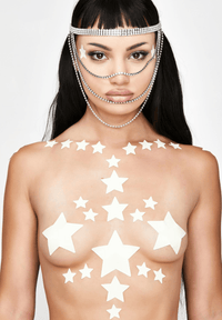 Glow in the dark star nipple sticker crop top worn by a model with a soft green yellow glow