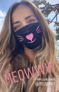 Black face mask with neon pink kitty whiskers that glow under blacklight laid out to show color and finish