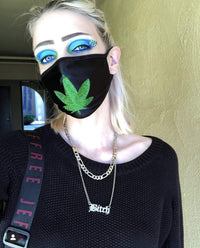 Front view of black face mask with a green glitter weed leaf with the full design visible