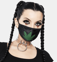 Black face mask with a green glitter weed leaf worn by a model