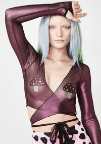 Model wearing sparkly pink glitter mushroom shaped nipple covers that glow under blacklight